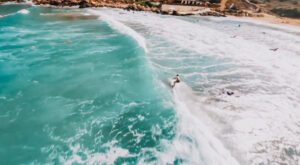 Surfer on a wave shot by a drone