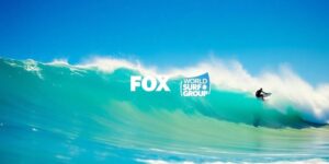 Surfers riding waves at a sunny beach.