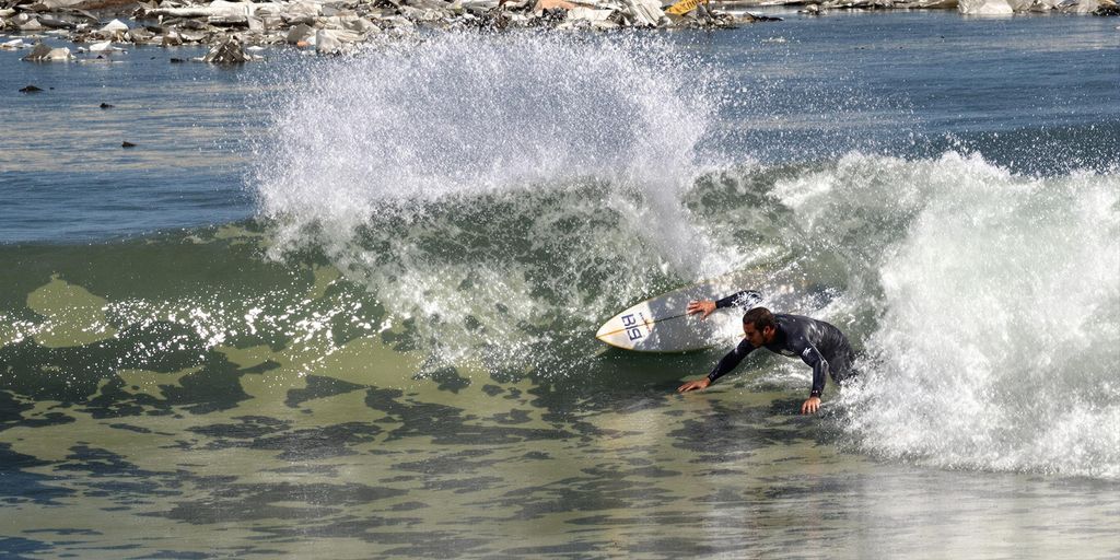 Surfer on polluted wave near Tijuana River.