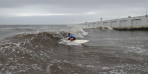 Surfer in polluted waves by Tijuana River.