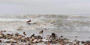 Surfer in polluted waters near Tijuana River.