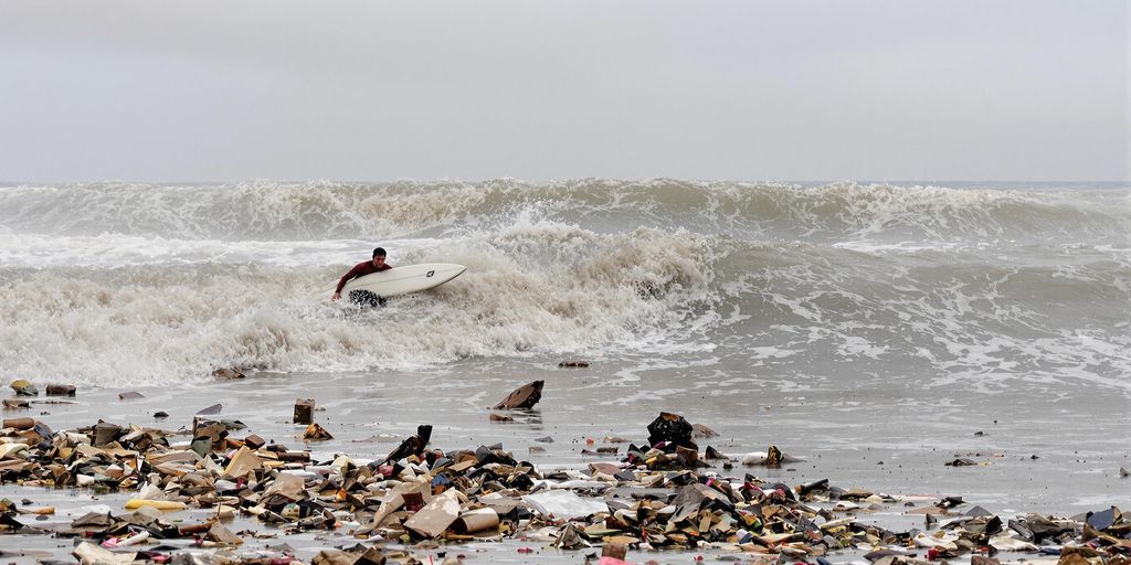 Surfer in polluted waters near Tijuana River.