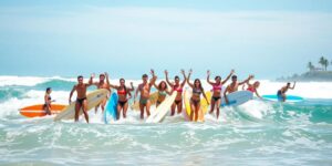 Surfers riding waves in a sunny beach setting.