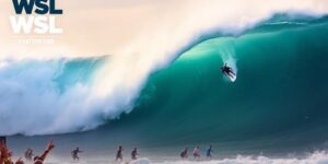 Professional surfers riding huge waves in vibrant ocean colors.