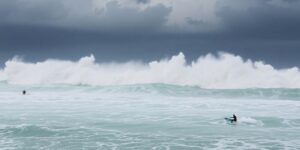 Surfers riding large waves at Burleigh Heads beach.