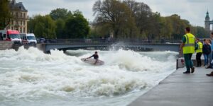 Surfer on Eisbachwelle surrounded by emergency responders.