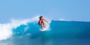 Gabriela Bryan surfing a wave in El Salvador competition.