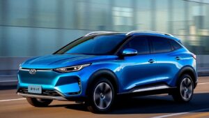 Blue BYD Dolphin Surf electric car driving on a road.