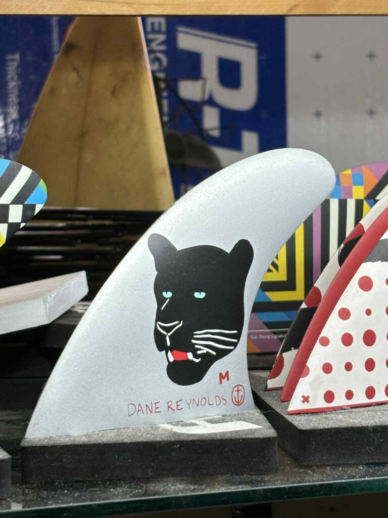 A black panther painted on a long board surf fin