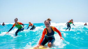 Female surfers competing in a sunny ocean.