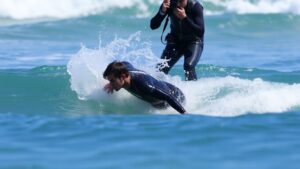 Surfer Filipe Toledo collides with photographer during surf competition.
