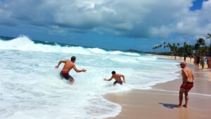 Lifeguards rescue swimmers from dangerous surf at beach.