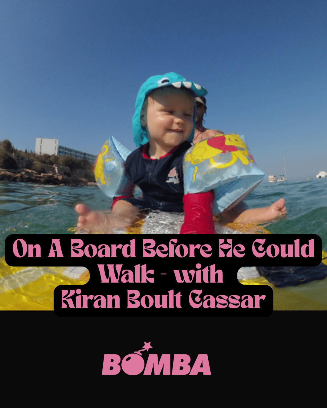 Baby riding a wave on a surfboard