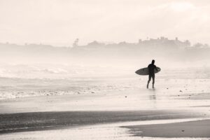 Surfer holding surfboard on a beach