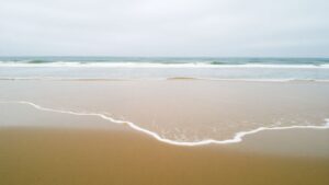 River floods Doheny State Beach after winter rain.