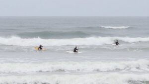 Surfers battling choppy waves at Pismo Beach competition.