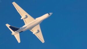 Modern airplane in flight against blue sky.