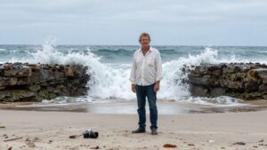 Broken camera on beach, former surf photographer alone.