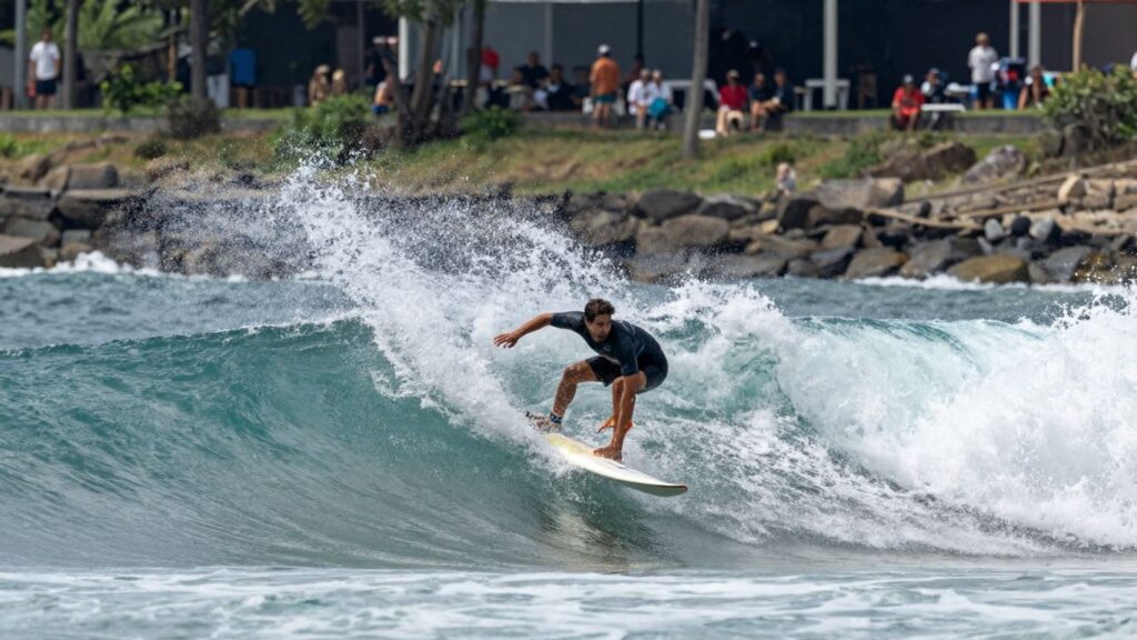 Surfers riding powerful waves in a championship competition.