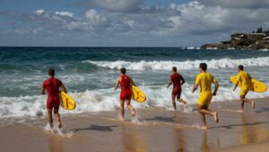 Lifesavers race into the waves at Bondi Beach.